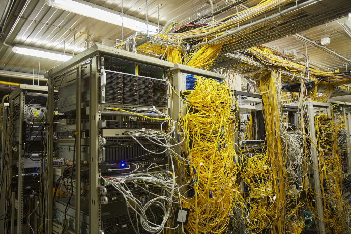 Picture of a dirty server room with yellow wires all over the place